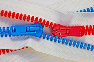 Blue and red zippers pulling in opposite directions