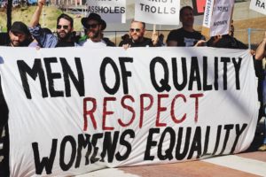 Men hold banner at rally supporting women's equality