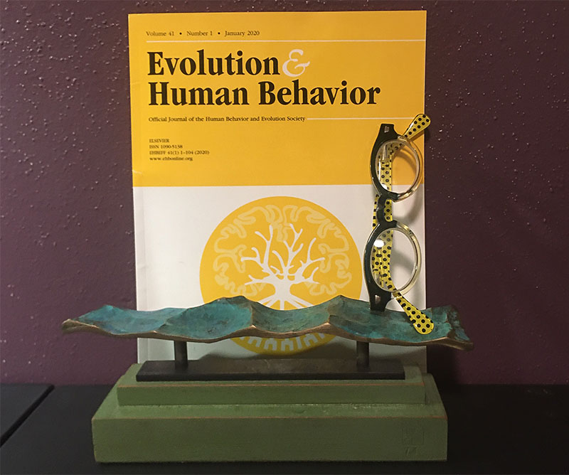 An issue of Evolution of Human Behavior Journal and reading glasses