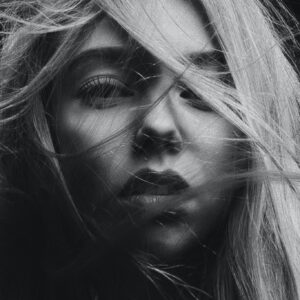 Face of young attractive woman with parted lips and wild hair