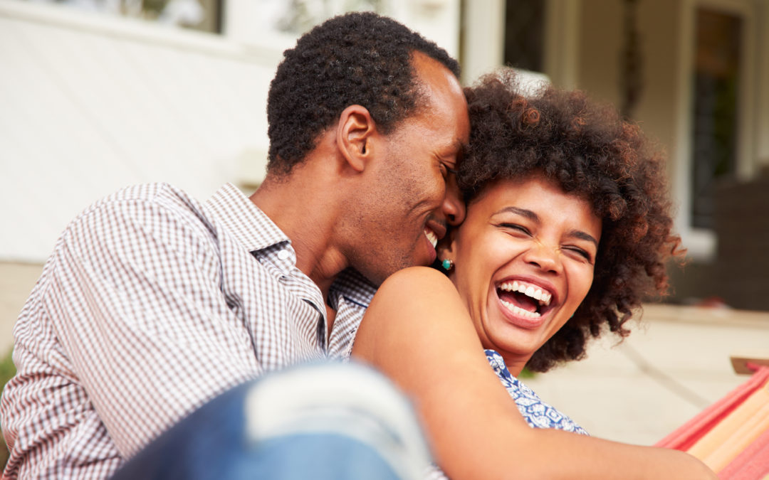 African-American man and woman couple laughing together